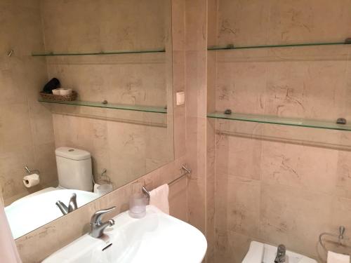 a bathroom with a sink and a toilet and a mirror at Paradise Beach in Porto Santo