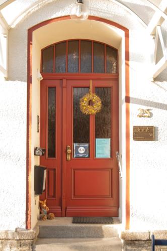 a red door with a wreath on it at Hotel - Pension Vesta in Bad Elster