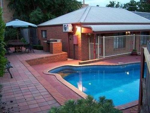 a swimming pool in front of a house at Bendigo Haymarket Motor Inn in Bendigo