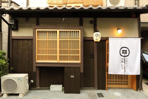 a building with a door and a sign on it at 京一軒町家 染 SEN 七条花畑 Shichijo-Hanabatake in Kyoto