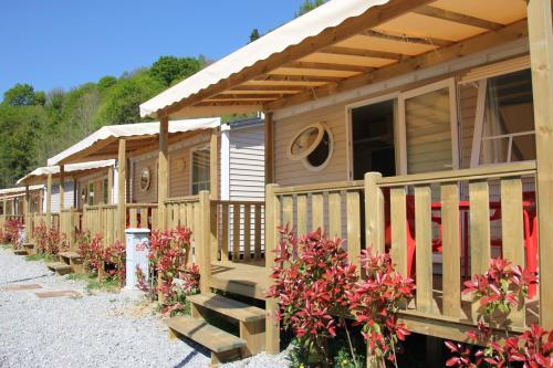 a row of wooden cottages with flowers in front at Camping Igara de San Sebastian in Donostia-San Sebastián