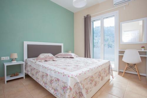 a white bedroom with a bed and a window at Vafkeri Apartments in Vavkerí