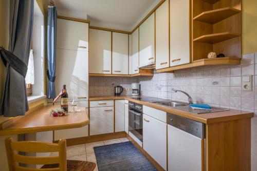 a kitchen with white cabinets and a sink at Ferienwohnungen Familie Rieder in Kaltenbach