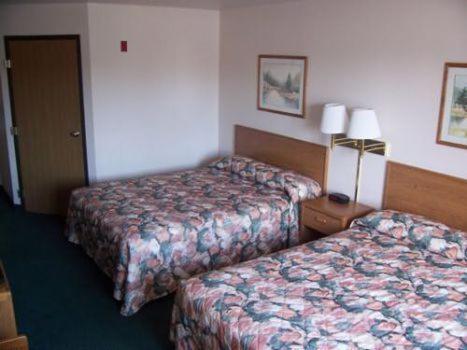 a hotel room with two beds and a television at Budget Host Inn & Suites North Branch in North Branch