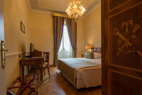 a bedroom with a bed and a table and a chandelier at Imperiale Palace Hotel in Santa Margherita Ligure