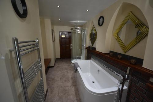 a large bathroom with a tub and a sink at The Smugglers Inn in Minehead