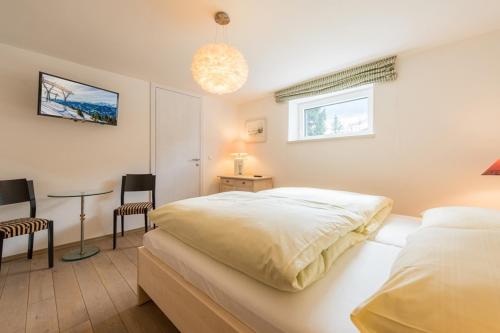 ein Schlafzimmer mit einem Bett und einem Tisch und Stühlen in der Unterkunft Haus Kissel in Saalbach-Hinterglemm