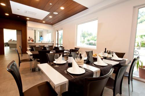 restauracja z czarnymi stołami i czarnymi krzesłami w obiekcie Hotel Rubino w orbole