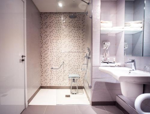 a bathroom with a shower and a sink at Golden Tulip Le Diplomate in Cotonou