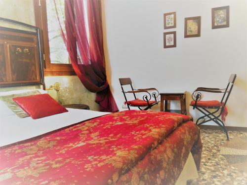 a bedroom with a bed and two chairs at Relais Alcova del Doge in Mira