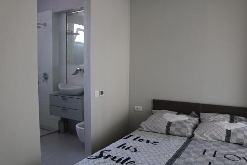 um quarto com uma cama e uma casa de banho com um lavatório em Apartment Splendid em Split