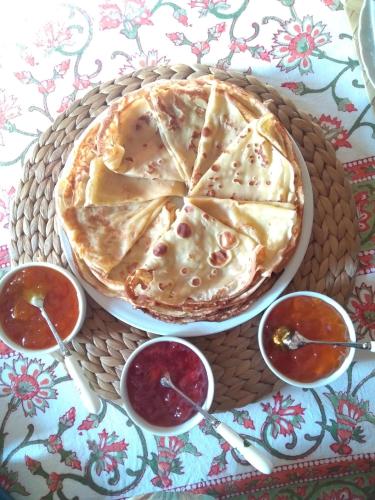 une tarte sur une table avec trois bols de sauce dans l'établissement Manoir de Kerguéréon, à Ploubezre