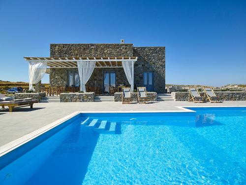 a swimming pool in front of a villa at Lithos Luxury Rooms (Adults Only) in Adamantas