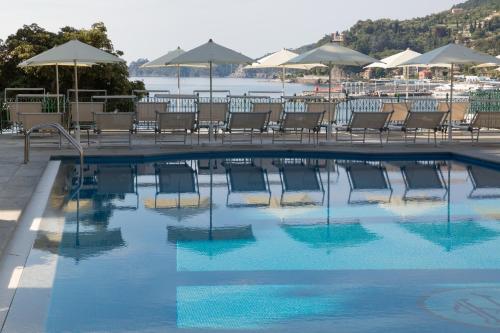 a swimming pool with chairs and umbrellas at Imperiale Palace Hotel in Santa Margherita Ligure