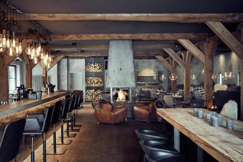 a restaurant with a bar with chairs and a fireplace at Landhaus Flottbek Boutique Hotel in Hamburg