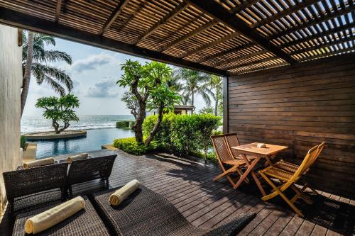 a patio with a table and chairs and the ocean at Aleenta Hua Hin - Pranburi - The Small Luxury Hotels of the World in Pran Buri