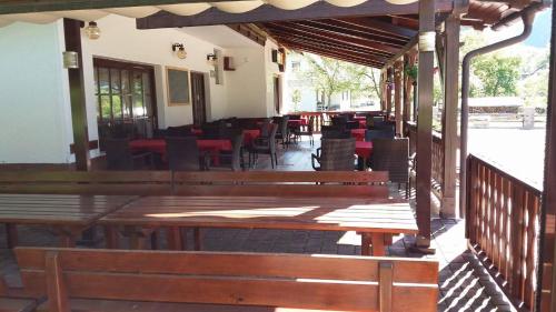 un restaurant avec des bancs en bois, des tables et des chaises dans l'établissement Gostišče Hedvika, à Kal-Koritnica