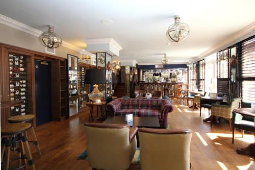 a living room with a couch and a table and chairs at Les Rocquettes Hotel in St Peter Port