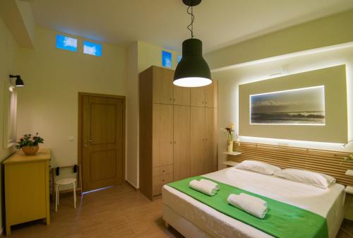 a bedroom with a bed with two towels on it at Castello Di Porto in Panormos Rethymno