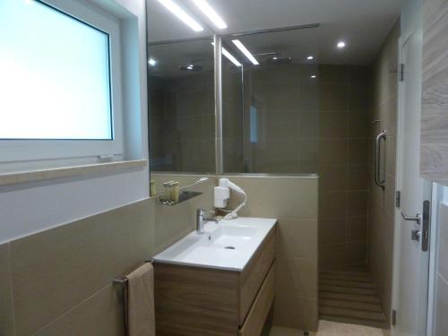 a bathroom with a sink and a mirror at Club Santana Beach & Resort in SantʼAna