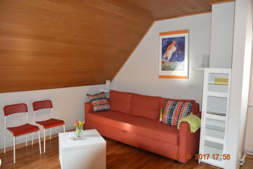 a living room with a red couch and two chairs at Damon II in Poelkapelle