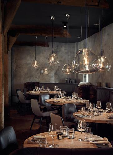 a restaurant with wooden tables and chairs and lights at Landhaus Flottbek Boutique Hotel in Hamburg