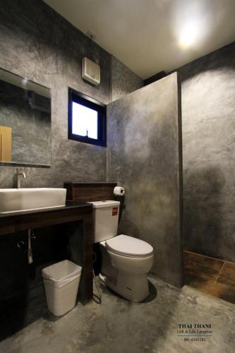 a bathroom with a toilet and a sink at THAI THANI Loft & Life Lamphun in Lamphun