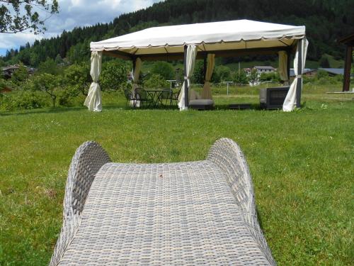 a couch sitting in the grass with a tent at Monaco Sport Hotel in Santo Stefano di Cadore