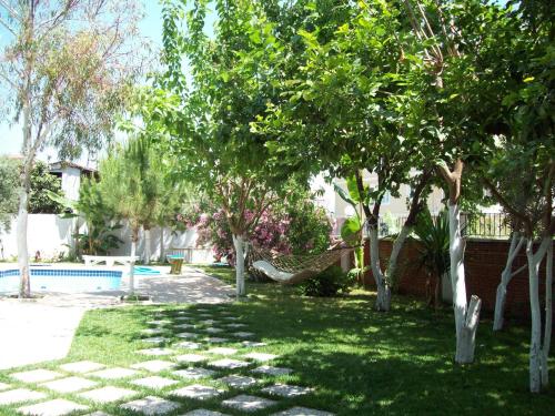 a yard with trees and a hammock near a pool at Hotel Vanilla in Fethiye