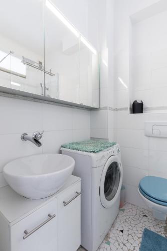 une salle de bain blanche avec une machine à laver et un lavabo dans l'établissement Promenade des anglais Vue mer, à Nice