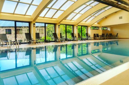 a swimming pool with chairs and a glass ceiling at Teghenis Resort in Tsaghkadzor