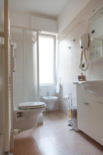 a white bathroom with a toilet and a sink at Allegroitalia Alassio Rosa in Alassio