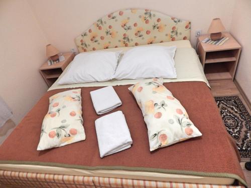 ein Bett mit zwei Kissen und Handtüchern darauf in der Unterkunft Rooms Camp Marina in Lozovac