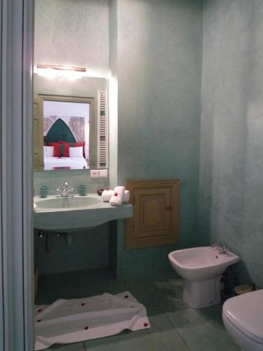 un bagno con lavandino, WC e specchio di Riad Azahar a Marrakech