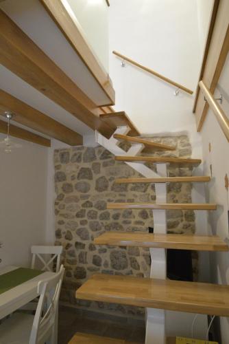 a staircase in a room with a stone wall at Apartments and Rooms Oliva in Cres