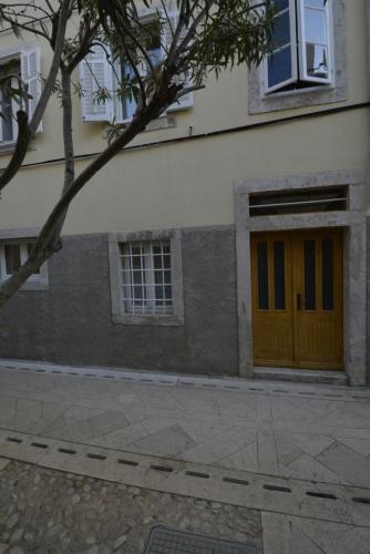 a building with a wooden door on the side of it at Apartments and Rooms Oliva in Cres