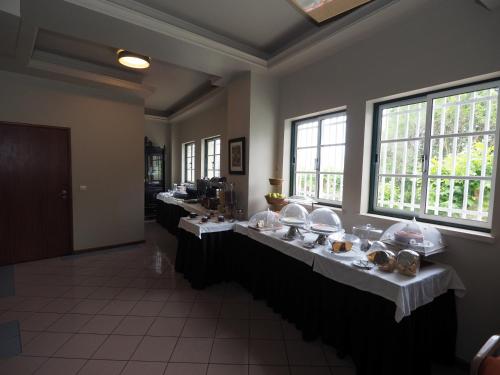 una habitación con una fila de mesas con comida en Residencial Imperial, en Luso