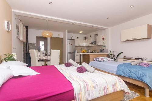 two beds in a room with a kitchen and a kitchen at Apartments Garmaz in Podgora