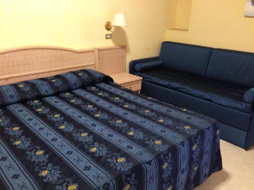 a bed and a couch in a hotel room at Allegroitalia Alassio Rosa in Alassio