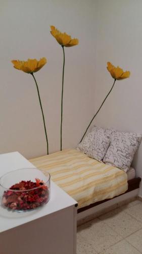 オルソラにあるApartamentos Los Vientos (Apto 3)のベッド1台、壁に花2本が飾られた部屋