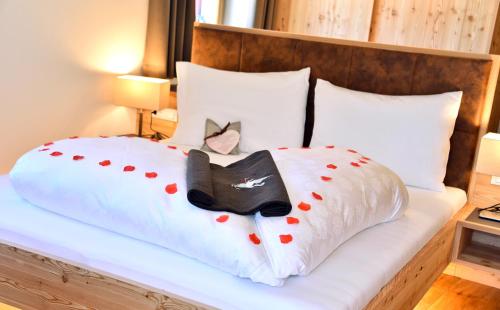 a bed with a black cat and a black shoe on it at Hotel Gsoihof in Villnoss