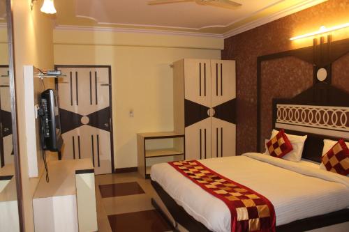 a bedroom with a bed and a television in it at Hotel Muskan Palace in Jaipur