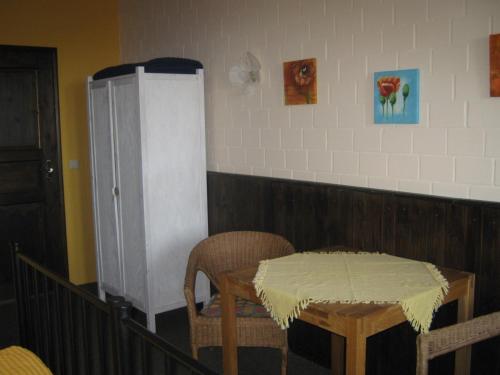een keuken met een tafel en stoelen en een koelkast bij Die bunte Kuh in Federow in Kargow
