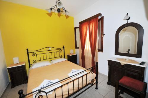 ein Schlafzimmer mit einem Bett, einem Waschbecken und einem Spiegel in der Unterkunft Kelenis Apartments in Karterados