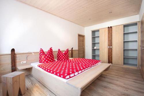 ein Schlafzimmer mit einem großen roten Bett mit roten Kissen in der Unterkunft Appartements Gahler - Kurort Oberwiesenthal in Kurort Oberwiesenthal