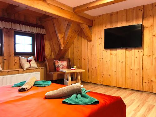 a room with a bed with a flat screen tv at Chata Emil Zatopek - Maraton - Lysa Hora in Krásná