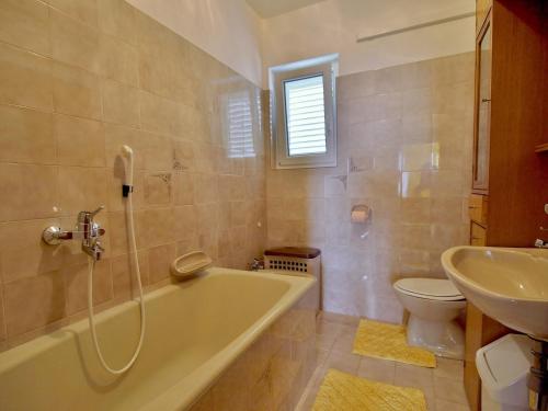 a bathroom with a tub and a toilet and a sink at Apartments Panorama view Zeljko Scerbe in Rab