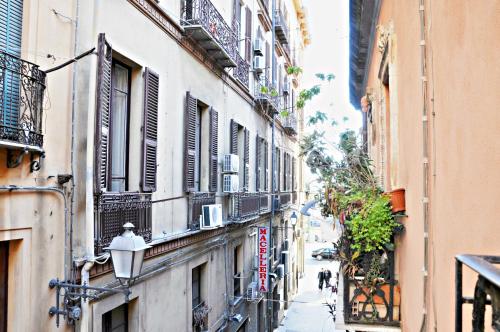 a narrow street with buildings and people walking down it at Abbardente appartamento in centro in Cagliari