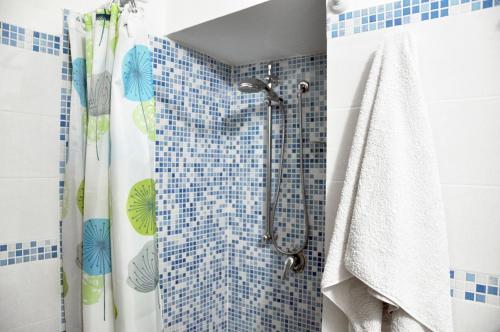 a bathroom with a shower with blue and green tiles at Abbardente appartamento in centro in Cagliari