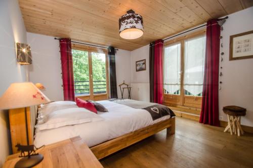 1 dormitorio con 1 cama grande y cortinas rojas en Appartement Acacia, en Chamonix-Mont-Blanc